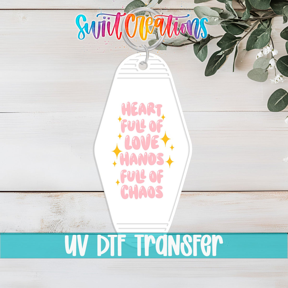 Heart Full of Love Hands Full of Chaos UV DTF transfer on a white motel keychain on a white wood table