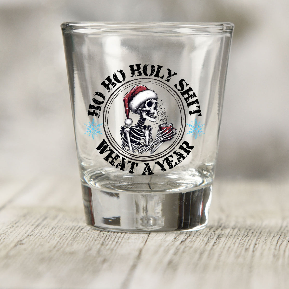 Ho Ho Holy Sh*t What a Year shot glass UV DTF transfer with skeleton in a Santa hat with a red mug on a clear shot glass