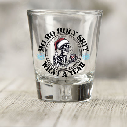Ho Ho Holy Sh*t What a Year shot glass UV DTF transfer with skeleton in a Santa hat with a red mug on a clear shot glass