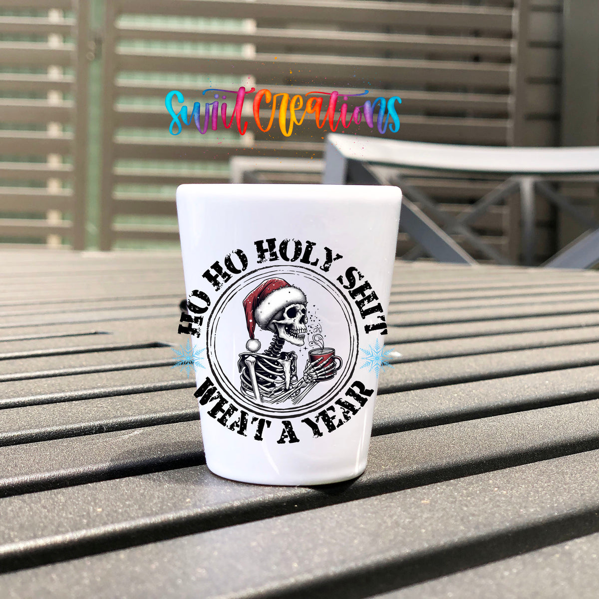 Ho Ho Holy Sh*t What a Year UV DTF transfer on a white shot glass on an outdoor patio table