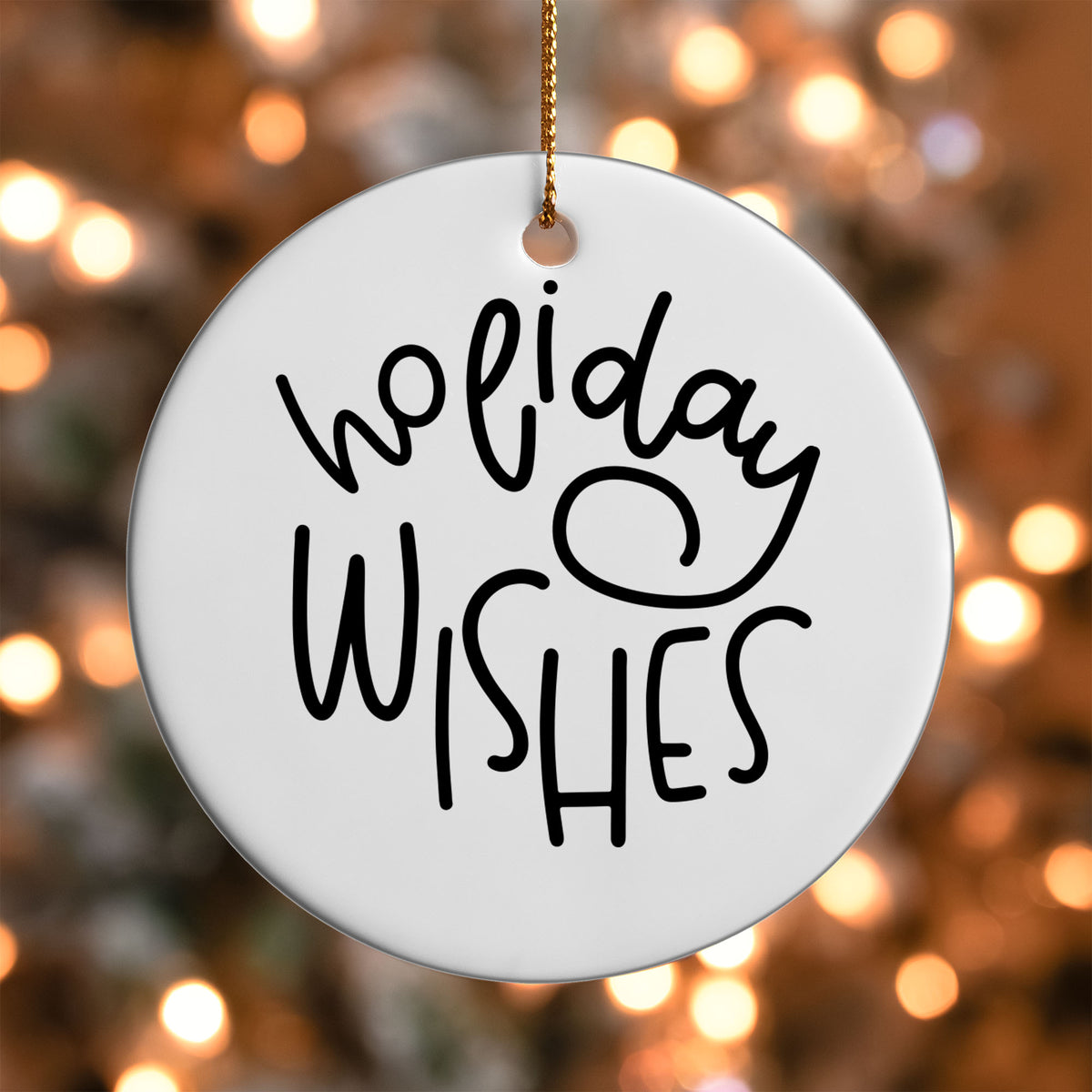 Holiday Wishes ornament UV DTF transfer on a round white ornament with a bokeh light background