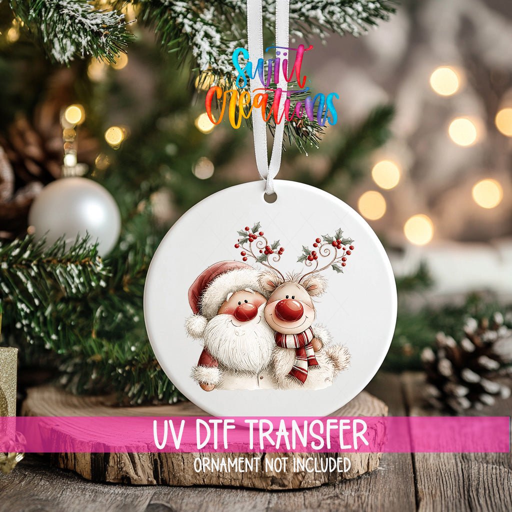 Holly Antler Reindeer ornament UV DTF transfer on an ornament resting on a wood slice beside a Christmas tree