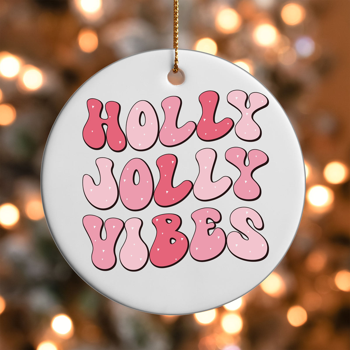 Holly Jolly Vibes ornament UV DTF transfer on a round white ornament with a bokeh light background