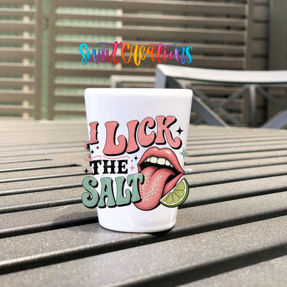 I Lick The Salt UV DTF transfer on a white shot glass on an outdoor patio table