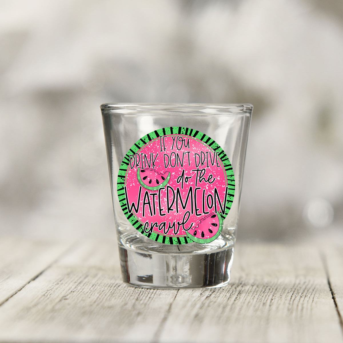 Close-up of the If You Drink Don't Drive Watermelon Crawl UV DTF transfer on a clear shot glass
