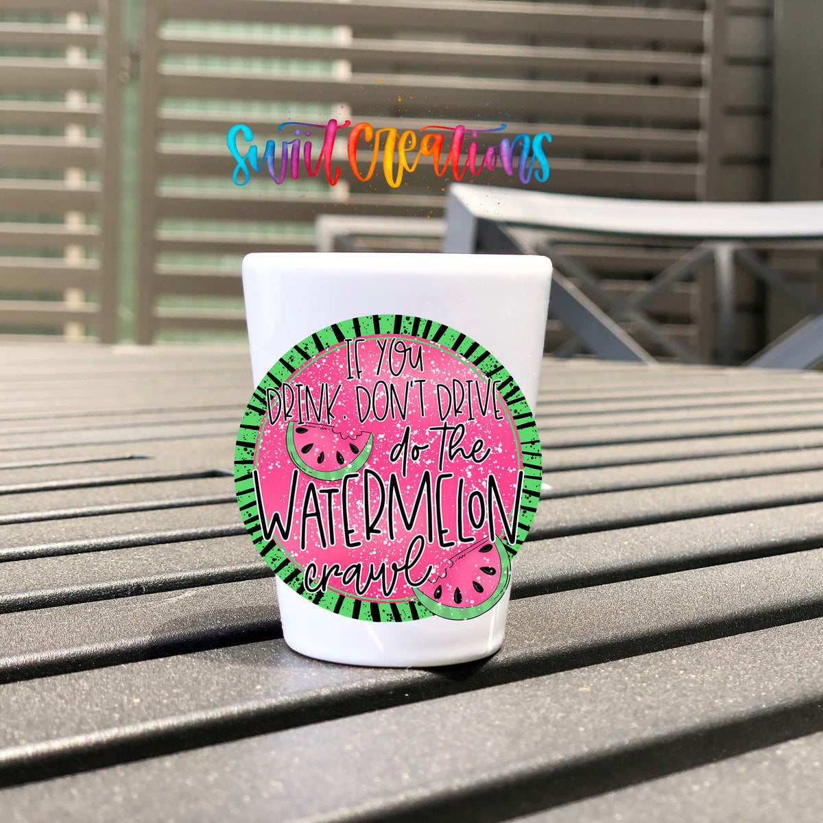 If You Drink Don't Drive Watermelon Crawl UV DTF transfer on a white shot glass on an outdoor patio table