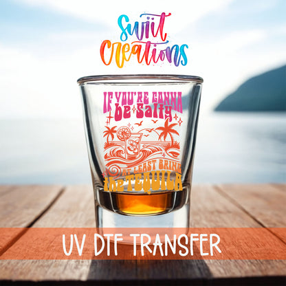 If You're Gonna Be Salty shot glass UV DTF transfer on a filled shot glass on a dock by the water