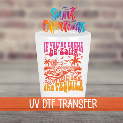 If You're Gonna Be Salty UV DTF transfer on a white shot glass in front of a brick wall
