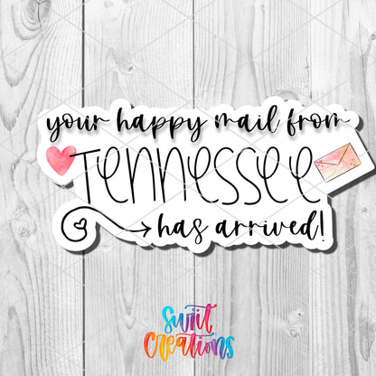 Close-up of happy mail from Tennessee sticker on white wood