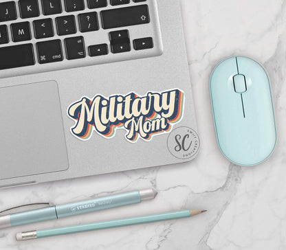 Retro Military Mom vinyl sticker on a silver laptop next to a mint mouse and pens