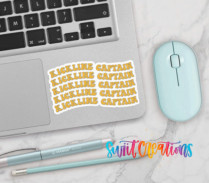 Gold Retro Kickline Captain vinyl sticker on a silver laptop next to a mint mouse and pens