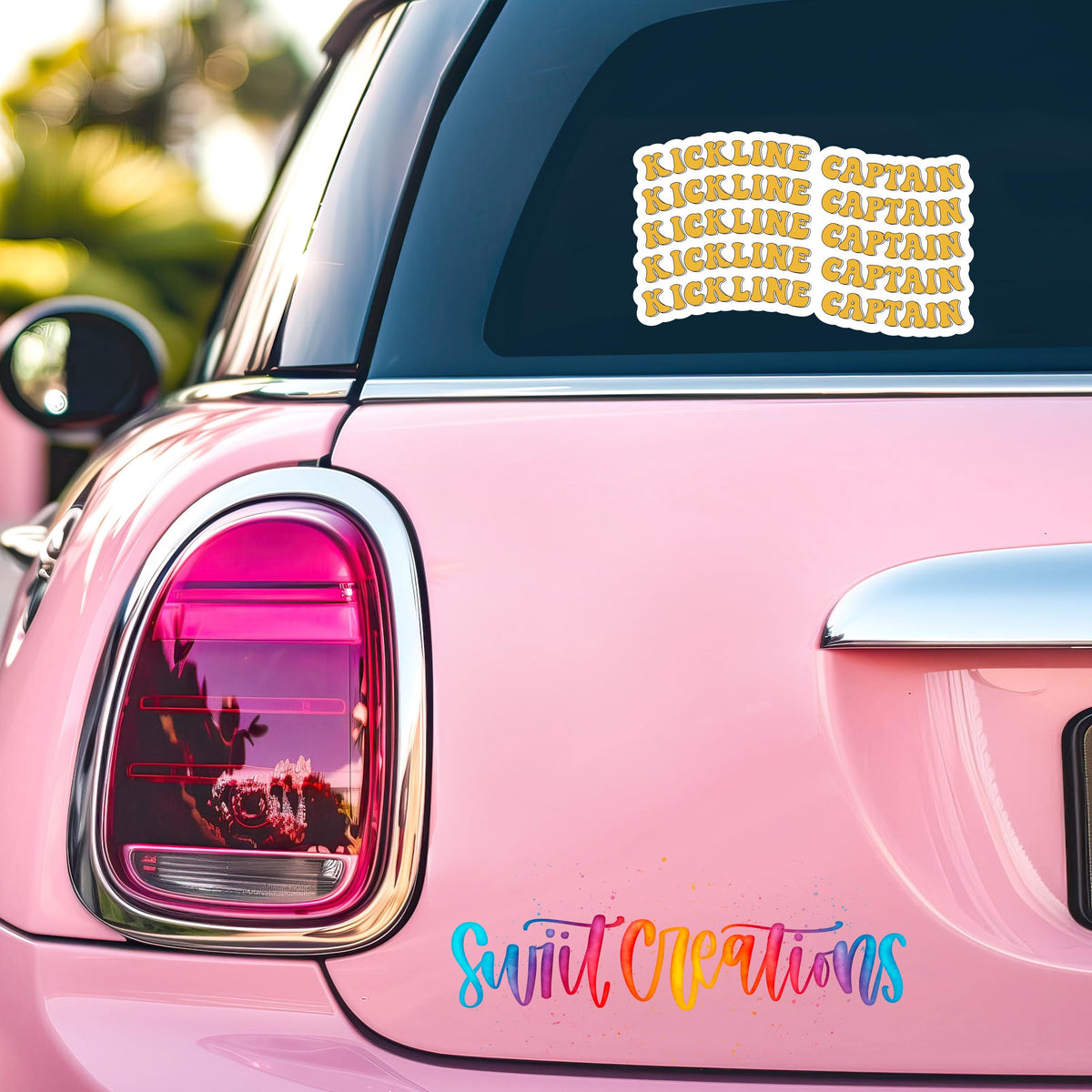 Gold Retro Kickline Captain sticker on the back window of a pink car