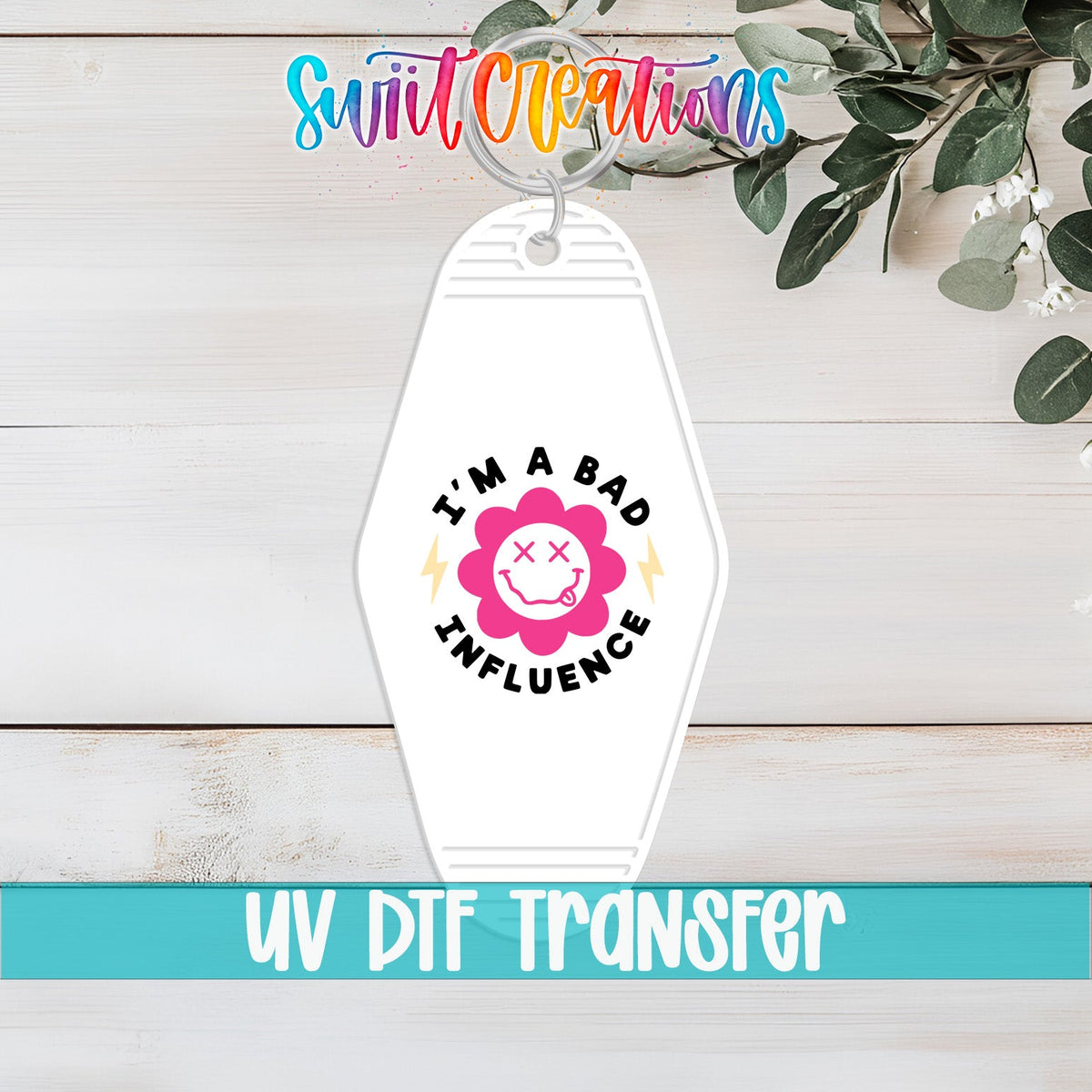 I'm a Bad Influence UV DTF transfer on a white motel keychain on a white wood table
