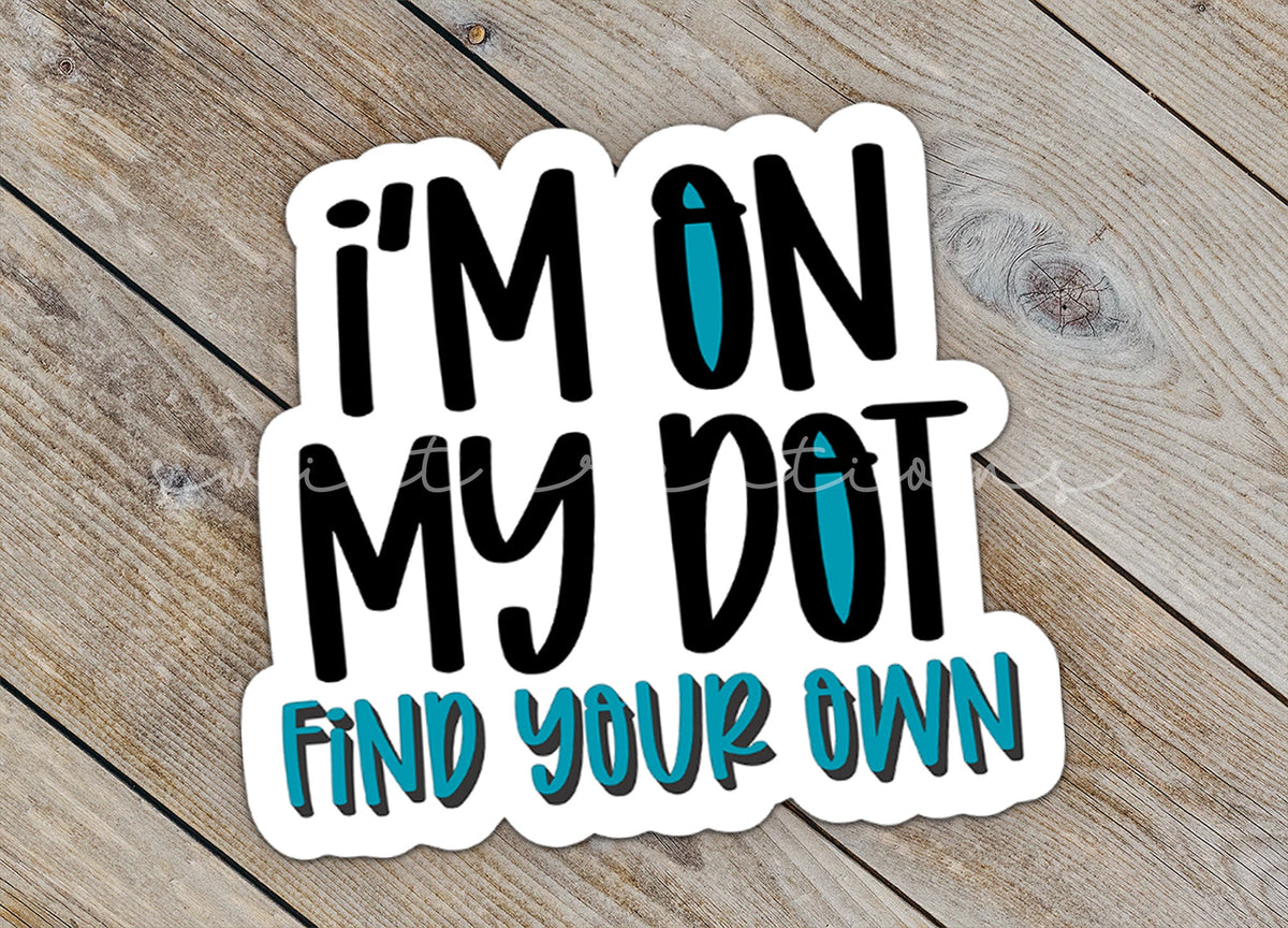 Close-up of the I'm On My Dot sticker on rustic wood