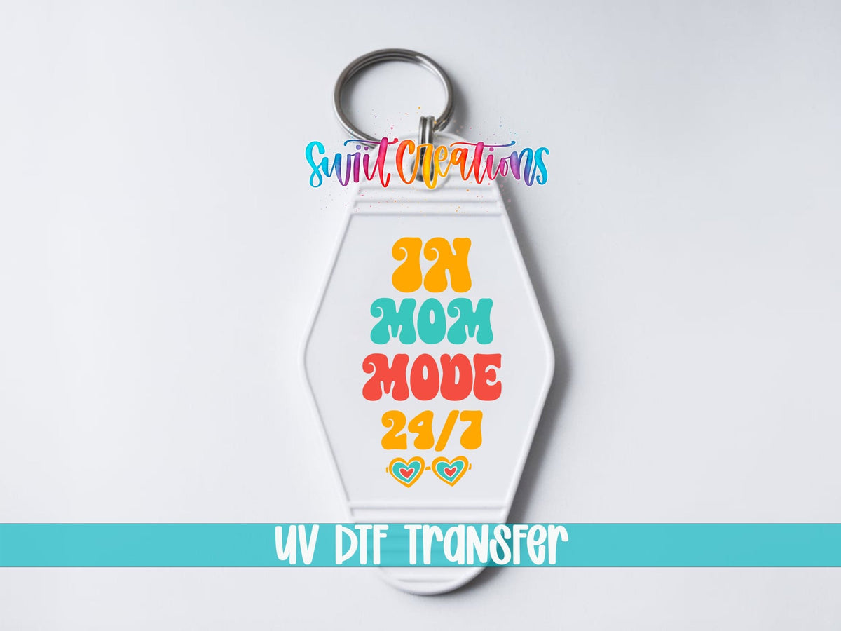 In Mom Mode 24/7 UV DTF transfer on a white motel keychain on a white background