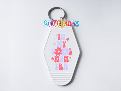 Close-up of the In My Cool Mom Era UV DTF transfer on a white motel keychain