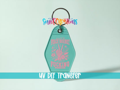 Inner Peace Begins With Four Words UV DTF transfer on a teal motel keychain on a mint background