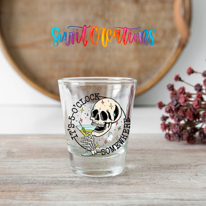 It's 5 O'Clock Somewhere shot glass transfer on a clear glass beside a wooden barrel and dried flowers