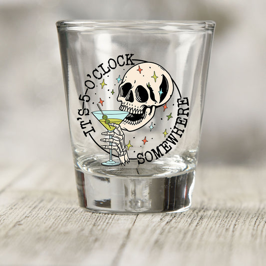 It's 5 O'Clock Somewhere shot glass UV DTF transfer with skull with a martini and skeleton hand on a clear shot glass