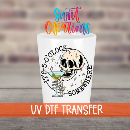 It's 5 O'Clock Somewhere UV DTF transfer on a white shot glass in front of a brick wall
