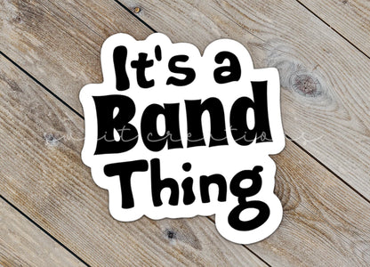 Close-up of the Black It's a Band Thing sticker on rustic wood