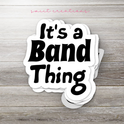 Stack of Black It's a Band Thing glossy stickers on a gray wood table