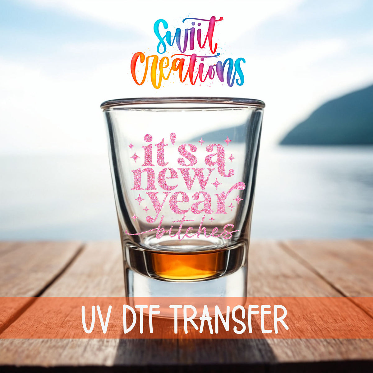 It's A New Year B*tches shot glass UV DTF transfer on a filled shot glass on a dock by the water