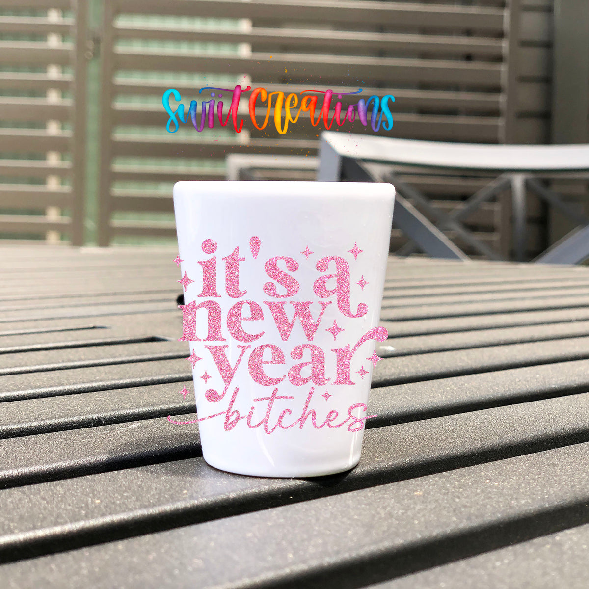 It's A New Year B*tches UV DTF transfer on a white shot glass on an outdoor patio table