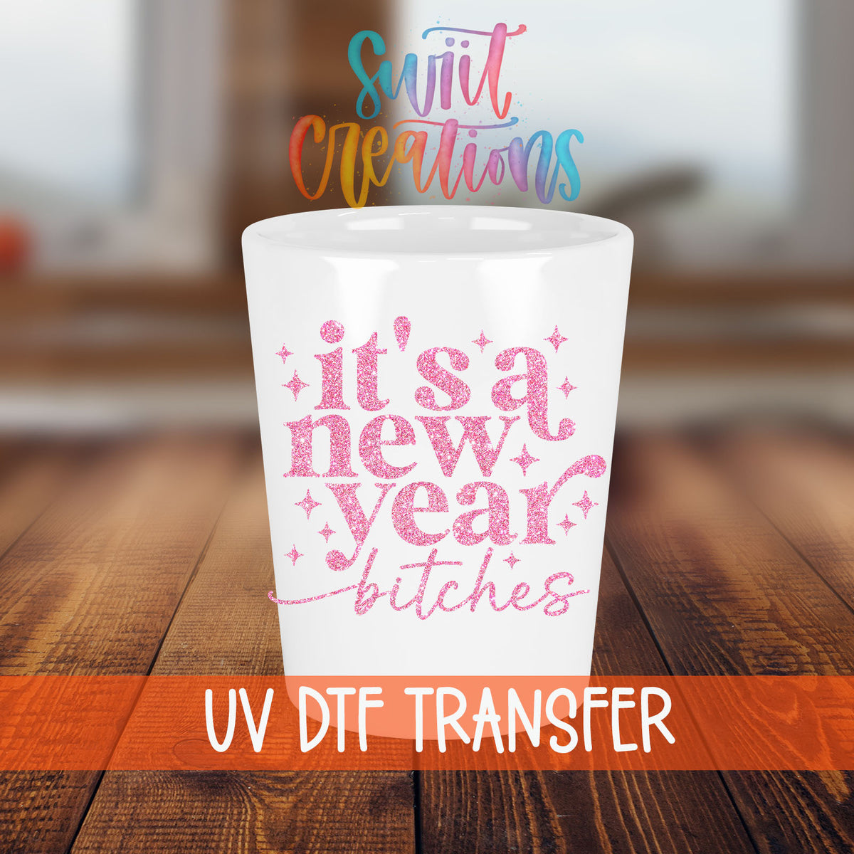 It's A New Year B*tches shot glass transfer on a white shot glass on a wooden table