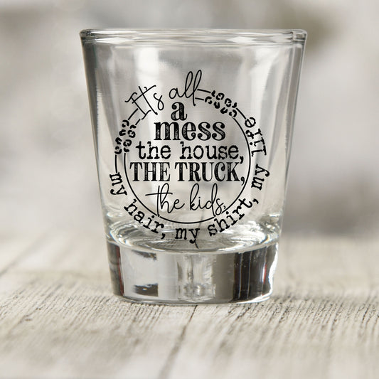 It's All A Mess shot glass UV DTF transfer with circular hand-lettered layout on a clear shot glass