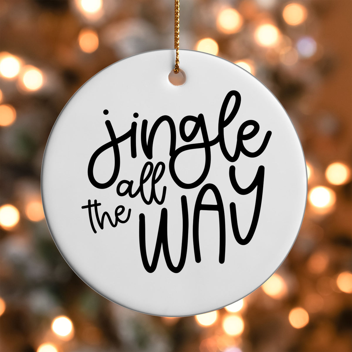 Jingle All the Way ornament UV DTF transfer on a round white ornament with a bokeh light background