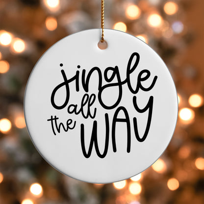 Jingle All the Way ornament UV DTF transfer on a round white ornament with a bokeh light background