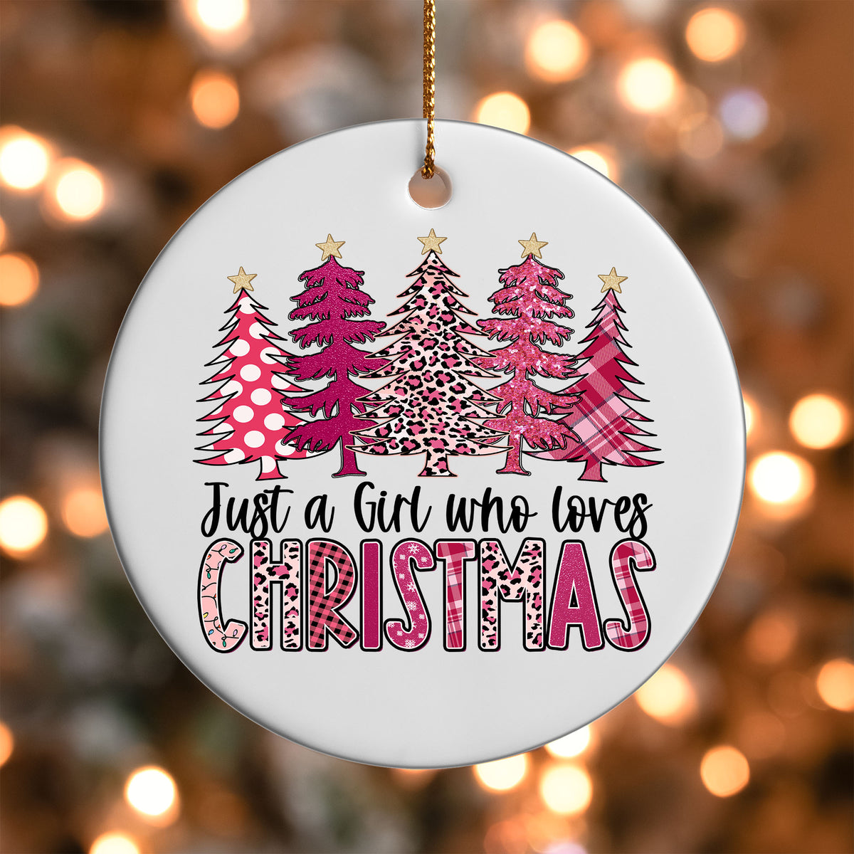 Just a Girl Who Loves Christmas ornament UV DTF transfer on a round white ornament with a bokeh light background