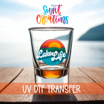 Lake Life shot glass UV DTF transfer on a filled shot glass on a dock by the water