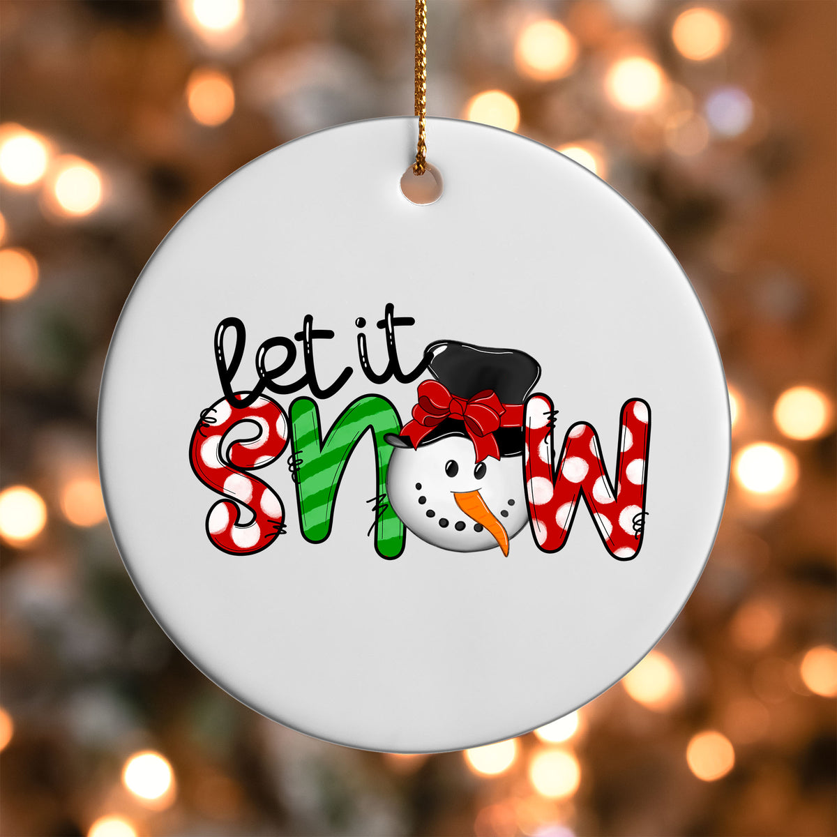 Let It Snow Patterned ornament UV DTF transfer on a round white ornament with a bokeh light background