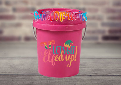 Let's Get Elfed Up UV DTF transfer on a pink mini bucket by a brick wall