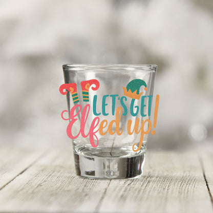 Close-up of the Let's Get Elfed Up UV DTF transfer on a clear shot glass