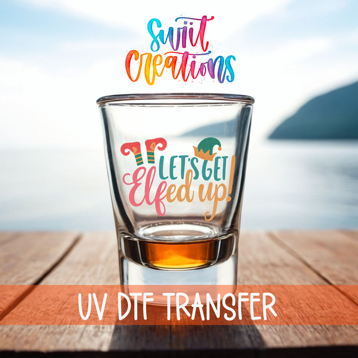 Let's Get Elfed Up shot glass UV DTF transfer on a filled shot glass on a dock by the water