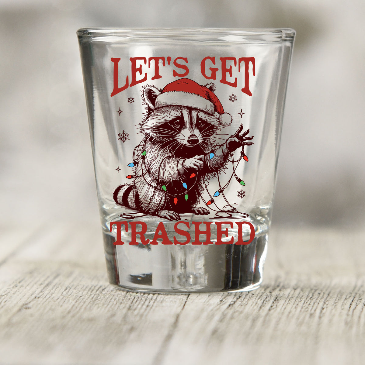 Let's Get Trashed Christmas shot glass UV DTF transfer with raccoon in a Santa hat with Christmas lights on a clear shot glass