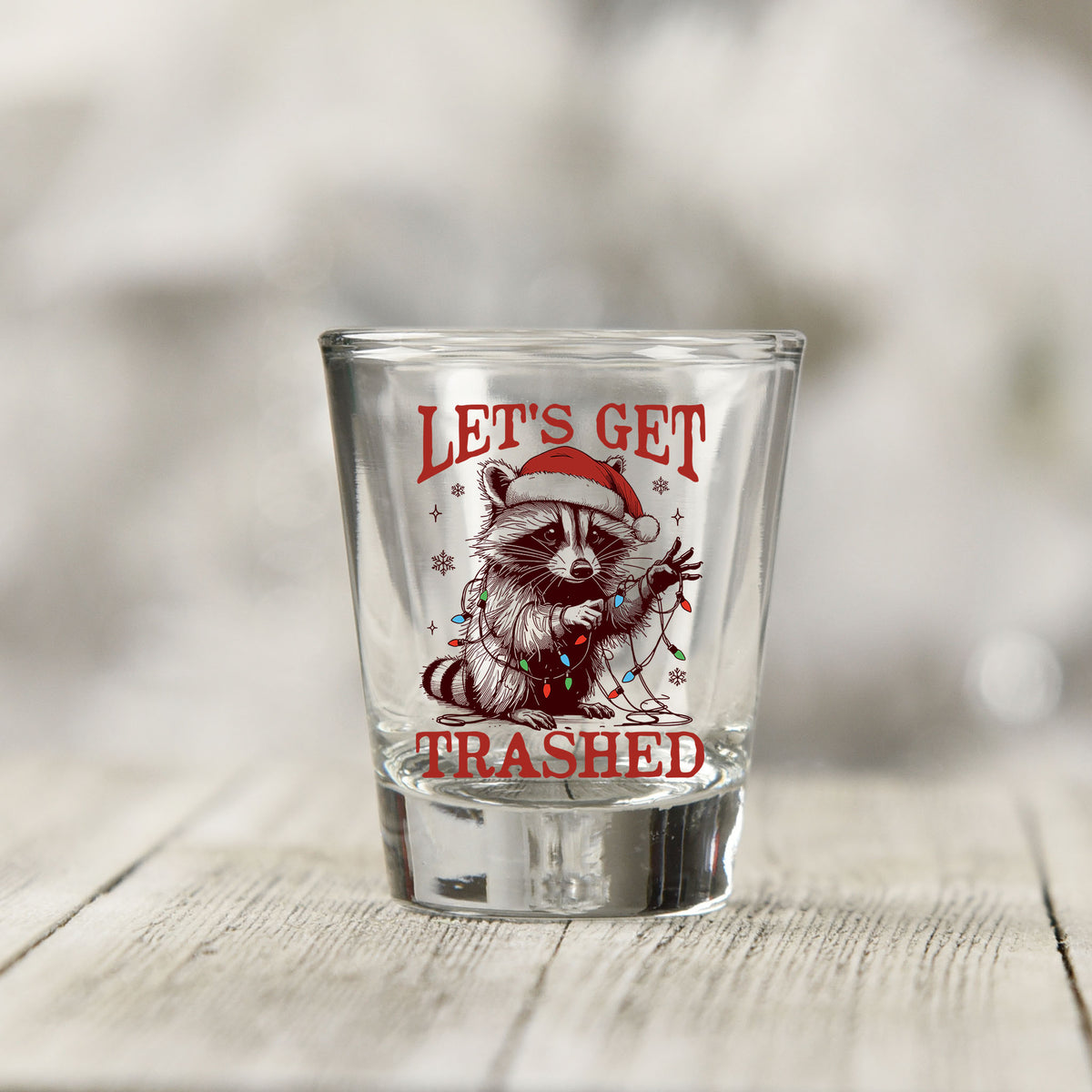Close-up of the Let's Get Trashed Christmas UV DTF transfer on a clear shot glass