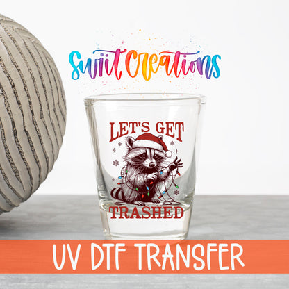 Let's Get Trashed Christmas UV DTF transfer on a clear shot glass with the Swiit Creations logo and UV DTF Transfer banner