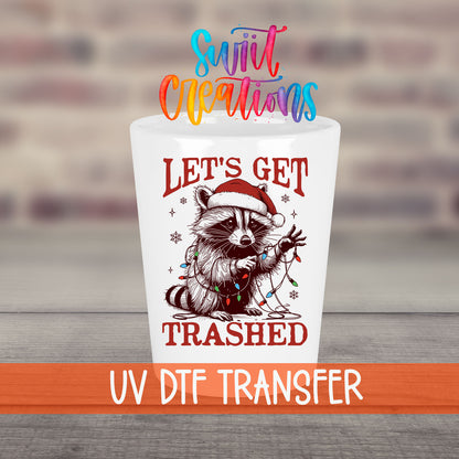 Let's Get Trashed Christmas UV DTF transfer on a white shot glass in front of a brick wall