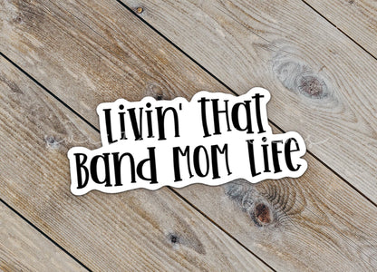 Close-up of the Black Band Mom Life sticker on rustic wood