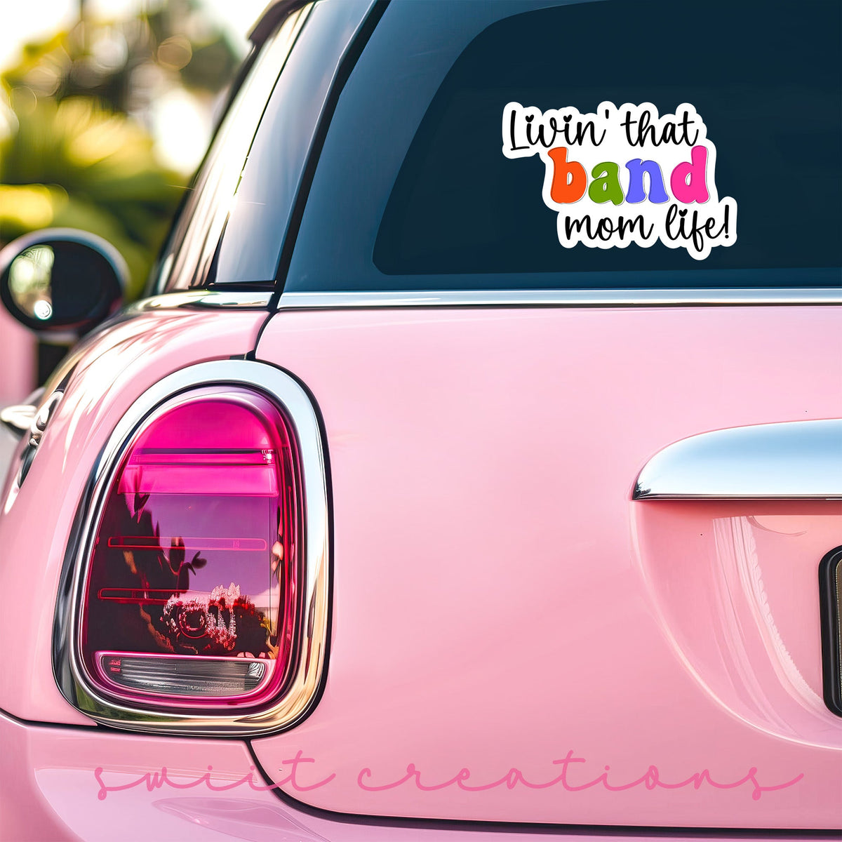 Rainbow Band Mom Life sticker on the back window of a pink car