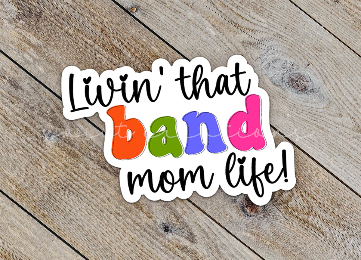 Close-up of the Rainbow Band Mom Life sticker on rustic wood
