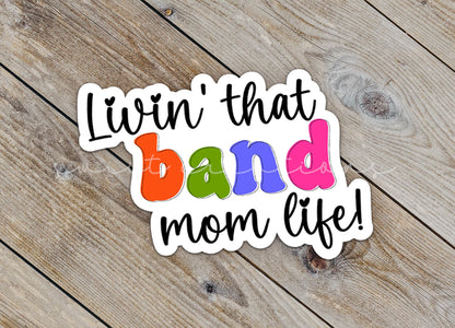 Close-up of the Rainbow Band Mom Life sticker on rustic wood