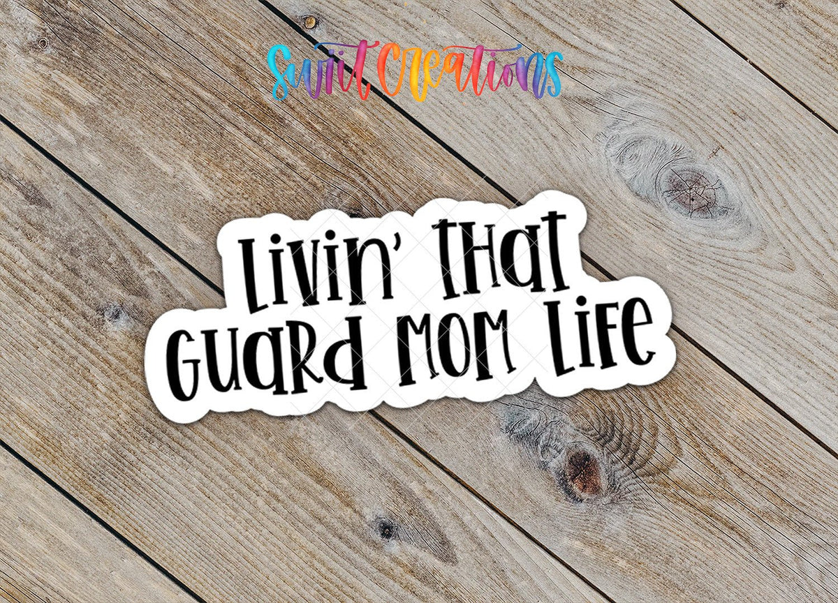 Close-up of the Livin' That Guard Mom Life sticker on rustic wood