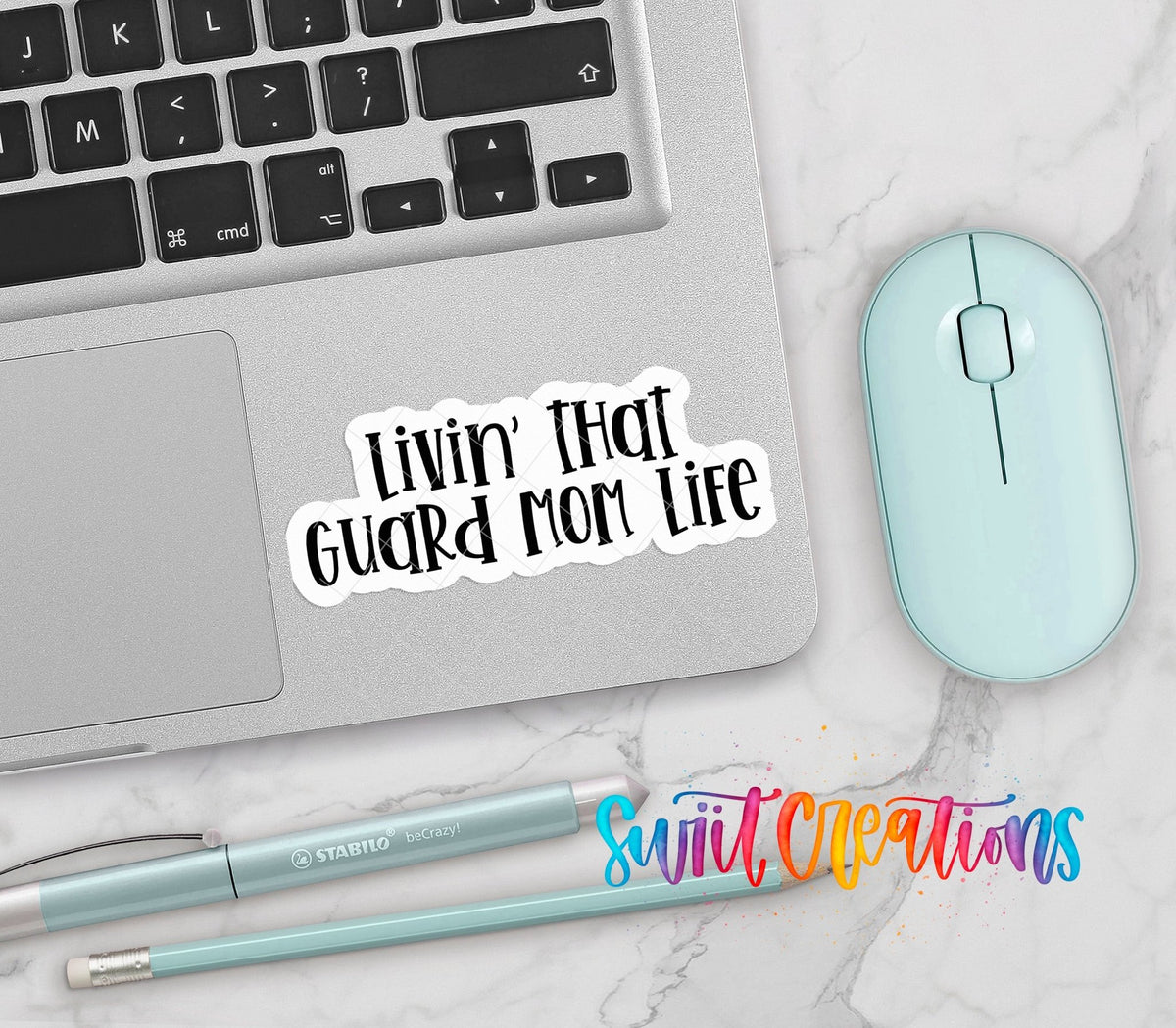 Livin' That Guard Mom Life vinyl sticker on a silver laptop next to a mint mouse and pens