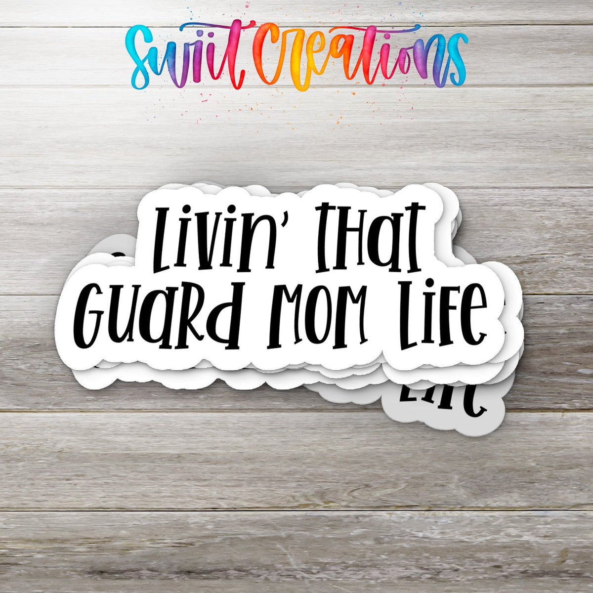 Stack of Livin' That Guard Mom Life glossy stickers on a gray wood table