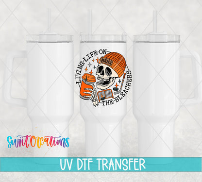 Living Life on the Bleachers skeleton in an orange mama cap UV DTF transfer on white 40 oz tumblers